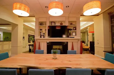 a dining room with a table and a fireplace at Hilton Garden Inn Oxnard/Camarillo in Oxnard