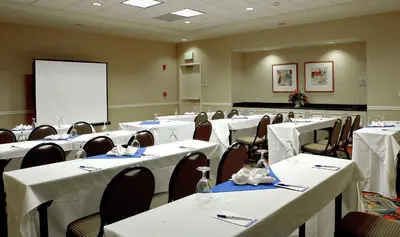 a conference room with white tables and chairs and a whiteboard at Hilton Garden Inn Oxnard/Camarillo in Oxnard