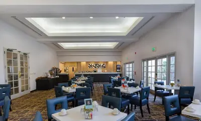 a dining room with tables and blue chairs at Best Western Posada Royale Hotel & Suites in Simi Valley
