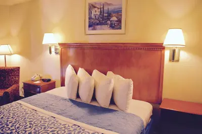 a hotel room with a bed with white pillows at Days Inn by Wyndham Anaheim Near the Park in Anaheim