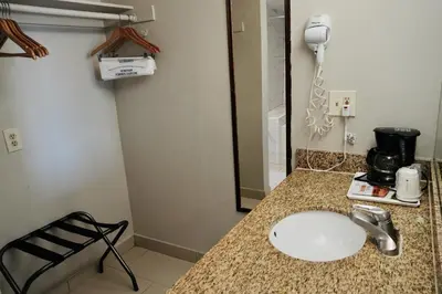 a bathroom with a sink and a phone on a counter at Days Inn by Wyndham Anaheim Near the Park in Anaheim
