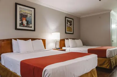 a hotel room with two beds with red and white sheets at Best Western Palm Garden Inn in Westminster
