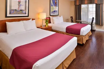 a hotel room with two beds and a table at Best Western Palm Garden Inn in Westminster