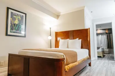 a bedroom with a large bed with a wooden headboard at Best Western Palm Garden Inn in Westminster