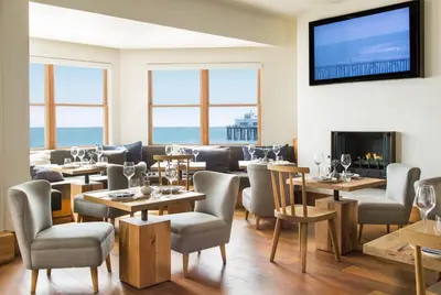 a restaurant with tables and chairs and a television on the wall at Malibu Beach Inn in Malibu