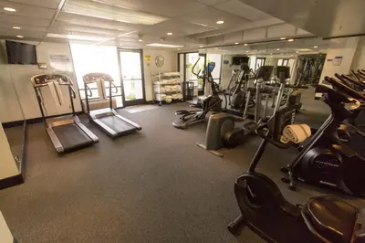 a gym with several treadmills and elliptical machines at Knott's Hotel in Buena Park