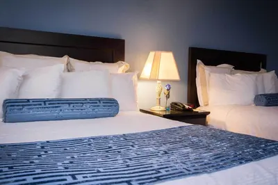 a hotel room with two beds and a lamp at Regency Inn in Los Angeles in Los Angeles