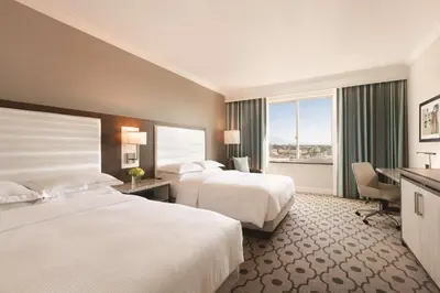 a hotel room with two beds and a desk at Hilton Los Angeles/San Gabriel in San Gabriel