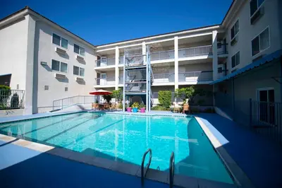 a swimming pool in front of a apartment building at Brookhurst Plaza Inn in Anaheim