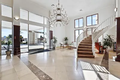 a large lobby with a staircase and a chandelier at Brookhurst Plaza Inn in Anaheim