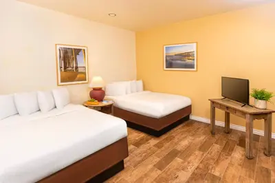 a hotel room with two beds and a television at Clocktower Inn Ventura in Ventura