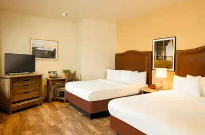 a hotel room with two beds and a television at Clocktower Inn Ventura in Ventura