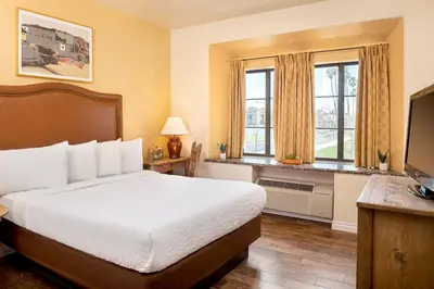 a hotel room with a bed and a television at Clocktower Inn Ventura in Ventura