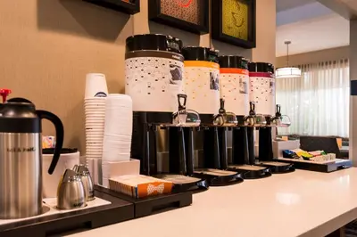 a kitchen counter with a bunch of cups and dishes at Hampton Inn Los Angeles-West Covina in West Covina