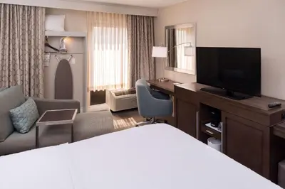 a hotel room with a bed and a desk and a television at Hampton Inn Los Angeles-West Covina in West Covina