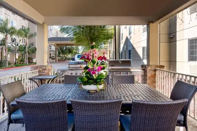 a table with chairs and a vase of flowers on a balcony at Candlewood Suites LAX Hawthorne by IHG in Hawthorne
