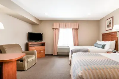 a hotel room with two beds and a television at Candlewood Suites LAX Hawthorne by IHG in Hawthorne
