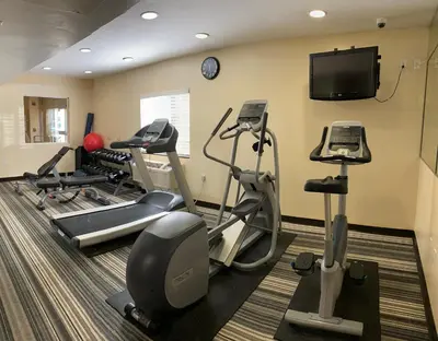 a gym with tread machines and a flat screen tv at Candlewood Suites LAX Hawthorne by IHG in Hawthorne