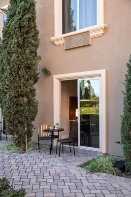a patio with a table and chairs in front of a building at Ayres Hotel Chino Hills Ontario in Chino Hills