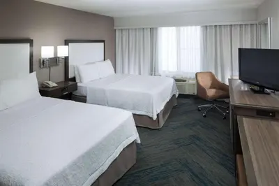 a hotel room with two beds and a flat screen tv at Hampton Inn Los Angeles Orange County Cypress in Cypress