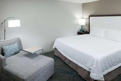 a hotel room with a bed and a chair at Hampton Inn Los Angeles Orange County Cypress in Cypress