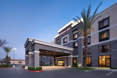 a hotel with a palm tree in front of it at Hampton Inn Los Angeles Orange County Cypress in Cypress