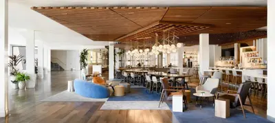 a restaurant with a blue couch and tables and chairs at Hilton Los Angeles-Culver City, CA in Los Angeles