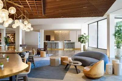 a living room with a couch and tables and chairs at Hilton Los Angeles-Culver City, CA in Los Angeles