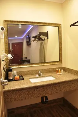 a bathroom with a sink and a large mirror at Sun Light Motel in Downey