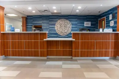 a waiting room with wooden cabinets and a blue wall at Fairfield Inn & Suites Anaheim North Buena Park in Buena Park