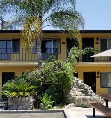 a building with a palm tree in front of it at Casa Bella Inn Downtown LA in Los Angeles