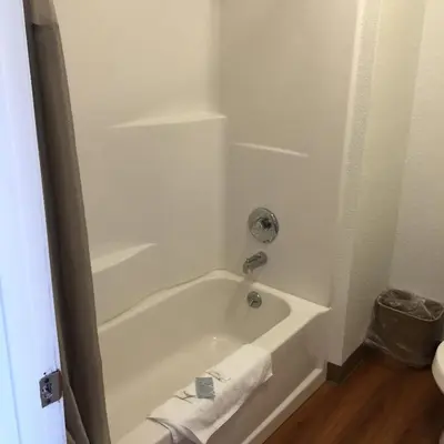 a bathroom with a white tub and a sink at Motel 6 Bakersfield in Bakersfield