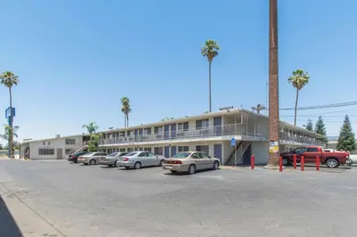 a parking lot with cars parked in front of a building at Motel 6 Bakersfield in Bakersfield