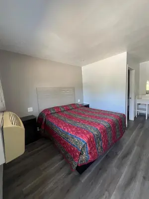 a bedroom with a bed with a red blanket at Eastsider Motel -Downtown LA New Rooms in Los Angeles
