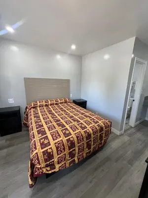 a bedroom with a bed with a blanket on it at Eastsider Motel -Downtown LA New Rooms in Los Angeles