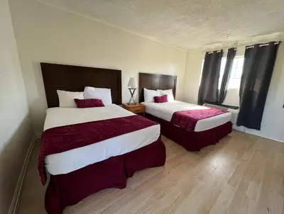 a hotel room with two beds with red sheets at Hometown Inn North Hills in North Hills