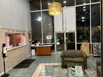a store with a lobby with a chair and a counter at Hometown Inn North Hills in North Hills