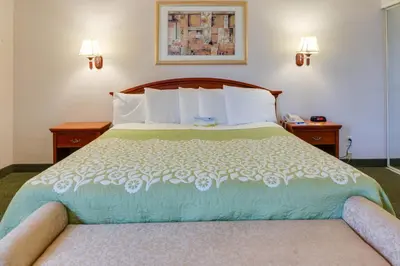 a hotel room with a bed and two night stands at Days Inn & Suites by Wyndham Fullerton in Fullerton