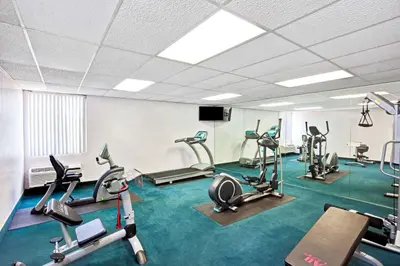 a gym with several treadmills and elliptical machines at Days Inn & Suites by Wyndham Fullerton in Fullerton