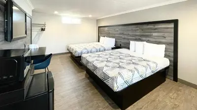 a hotel room with two beds and a flat screen tv at Motel 6 Pico Rivera - Los Angeles, CA in Pico Rivera
