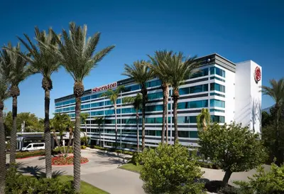 a hotel with palm trees in front of it at Sheraton Ontario Airport Hotel in Ontario