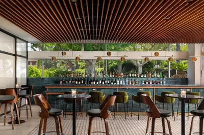 a restaurant with tables and chairs and a bar at Sheraton Ontario Airport Hotel in Ontario