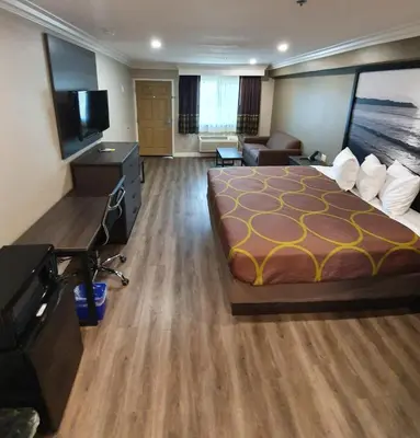 a hotel room with a bed and a flat screen tv at Super 8 by Wyndham Cypress Buena Park Area in Cypress