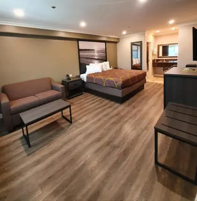 a hotel room with a bed and a couch at Super 8 by Wyndham Cypress Buena Park Area in Cypress
