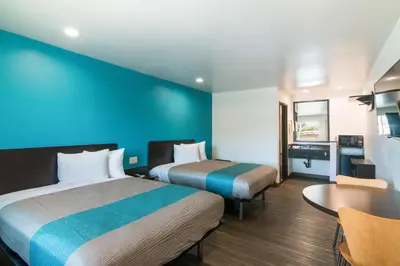 a hotel room with two beds and a table at Motel 6-South El Monte, CA - Los Angeles in South El Monte