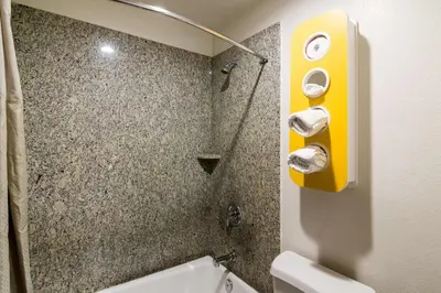 a bathroom with a shower with a yellow dispenser at Motel 6-South El Monte, CA - Los Angeles in South El Monte