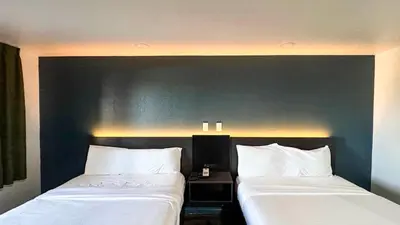 two beds sitting next to each other in a room at Motel 6 Barstow, CA - Lenwood Road in Barstow