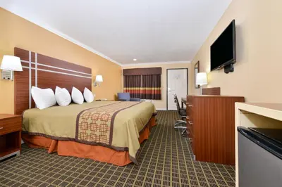 a hotel room with a bed and a flat screen tv at Americas Best Value Inn - Azusa/Pasadena in Azusa