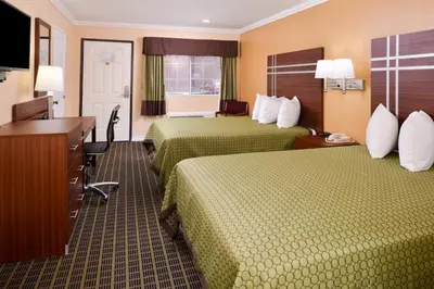 a hotel room with two beds and a desk at Americas Best Value Inn - Azusa/Pasadena in Azusa