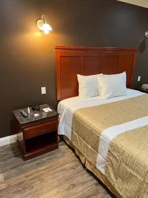 a hotel room with two beds and a side table at Travelodge by Wyndham Brea in Brea